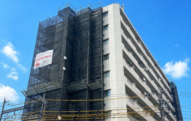 足場とシートで覆われた改修工事中のマンション