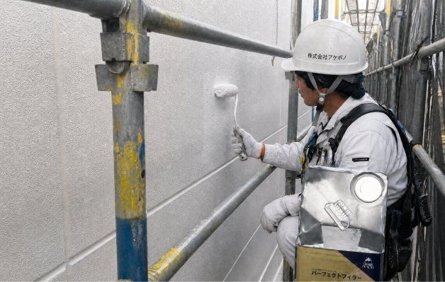 住宅の外壁を塗装する職人